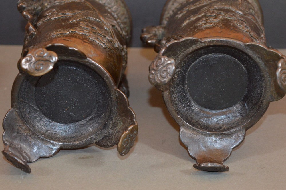 A pair of dark bronze Meiji period Japanese vases with high-relief figural decoration, dragon handles, and tripod bases. View XI