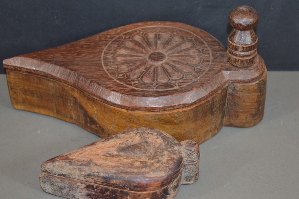 Pair of 19th-century Indian hand-carved teardrop-shaped hardwood spice boxes featuring intricate floral rosette motifs and a turned wood knob.