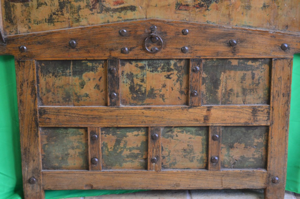 An arched antique Chinese wooden cart door featuring faded hand-painted figures, weathered green pigments, and iron studs. View III