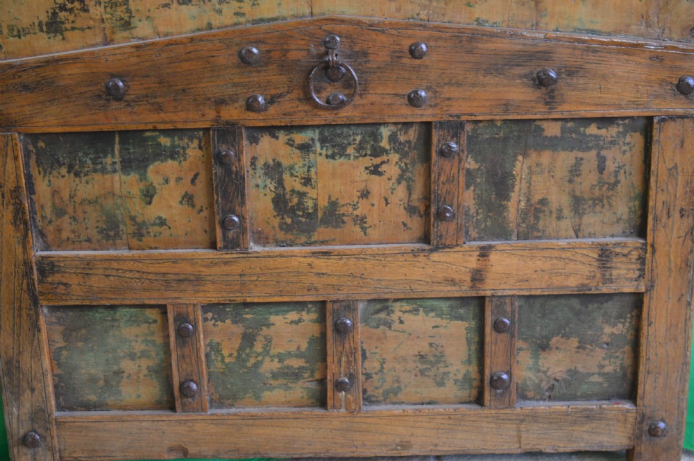 An arched antique Chinese wooden cart door featuring faded hand-painted figures, weathered green pigments, and iron studs. View V