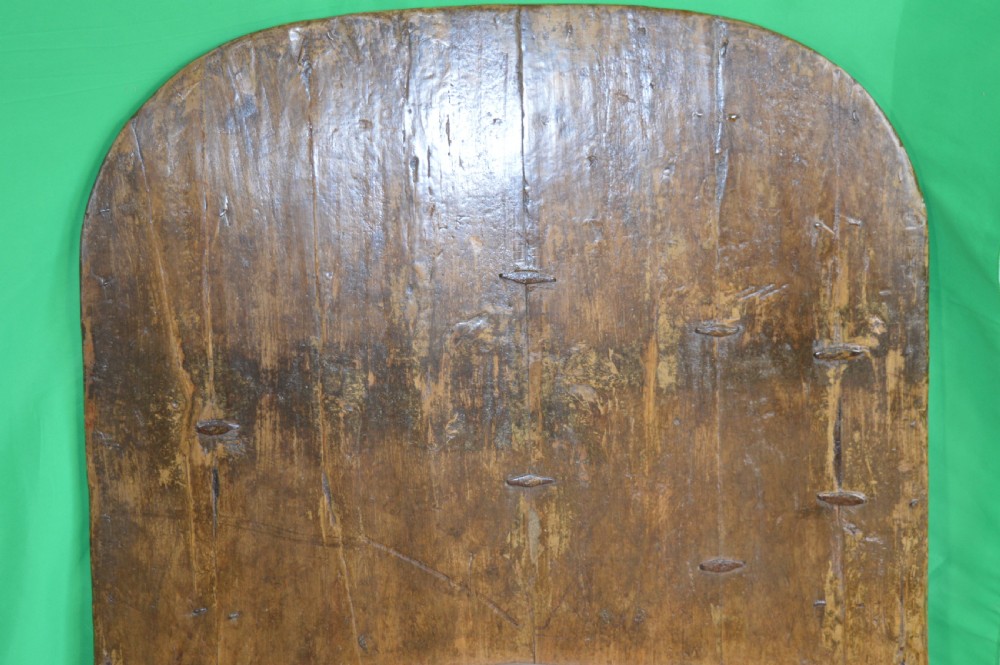 An arched antique Chinese wooden cart door featuring faded hand-painted figures, weathered green pigments, and iron studs. View XVII
