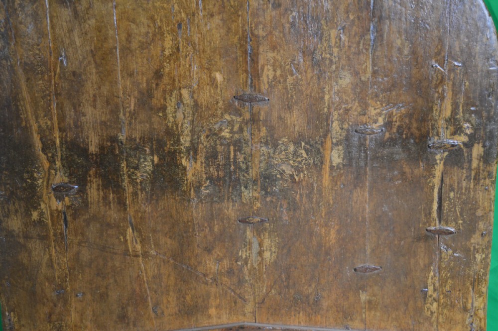 An arched antique Chinese wooden cart door featuring faded hand-painted figures, weathered green pigments, and iron studs. View XIX