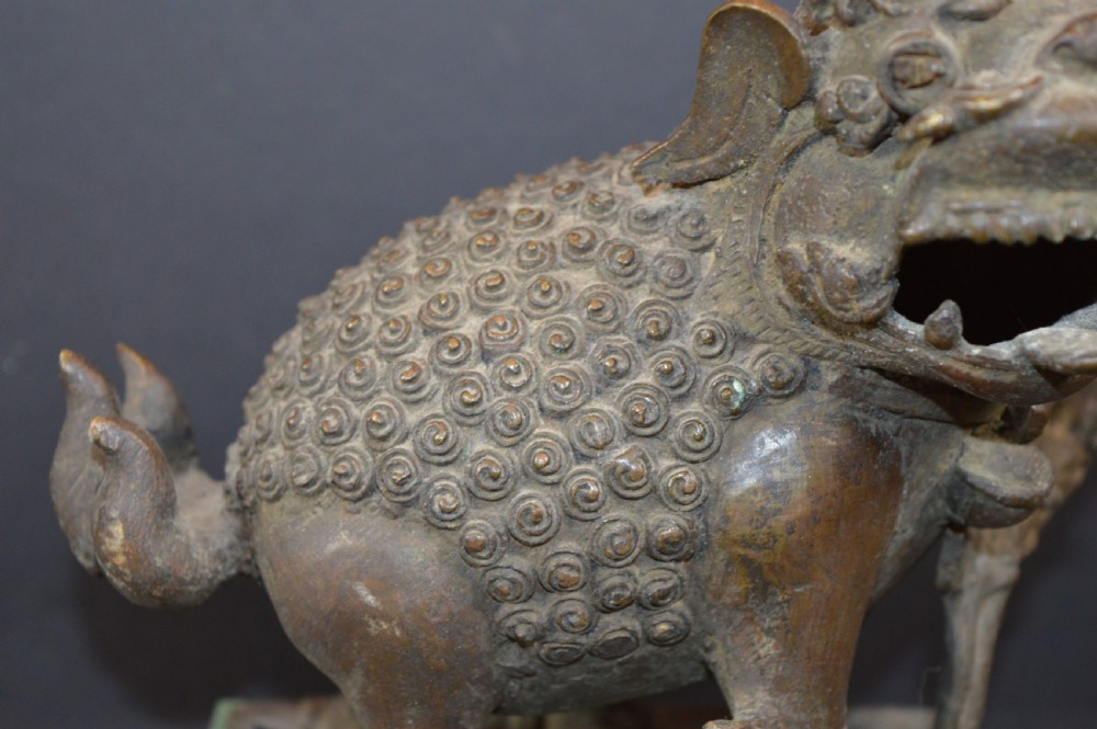 A late 18th-century Chinese bronze incense burner in the shape of a mythical Qilin creature with an open mouth standing on a pierced rectangular stand. View III