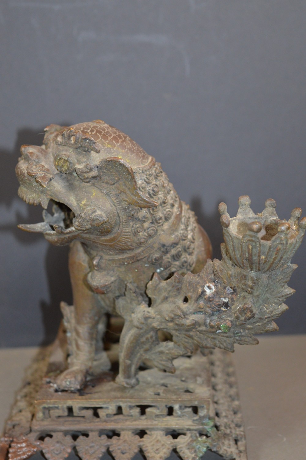 A late 18th-century Chinese bronze incense burner in the shape of a mythical Qilin creature with an open mouth standing on a pierced rectangular stand. View V