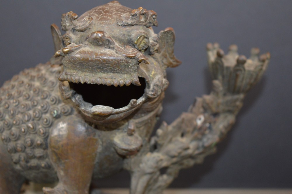 A late 18th-century Chinese bronze incense burner in the shape of a mythical Qilin creature with an open mouth standing on a pierced rectangular stand. View VI