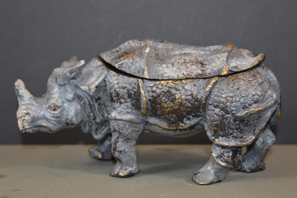 An antique Austrian cold-painted bronze inkwell cast in the detailed form of a standing rhinoceros with a hinged opening back.