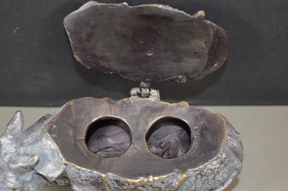 An antique Austrian cold-painted bronze inkwell cast in the detailed form of a standing rhinoceros with a hinged opening back. View II