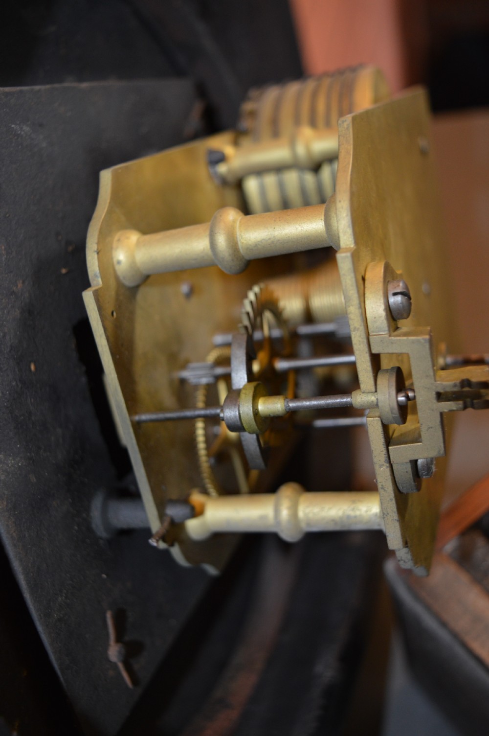 A Victorian mahogany drop dial fusee wall clock featuring a white circular dial with Roman numerals, carved side ears, and a lower pendulum window. View VII