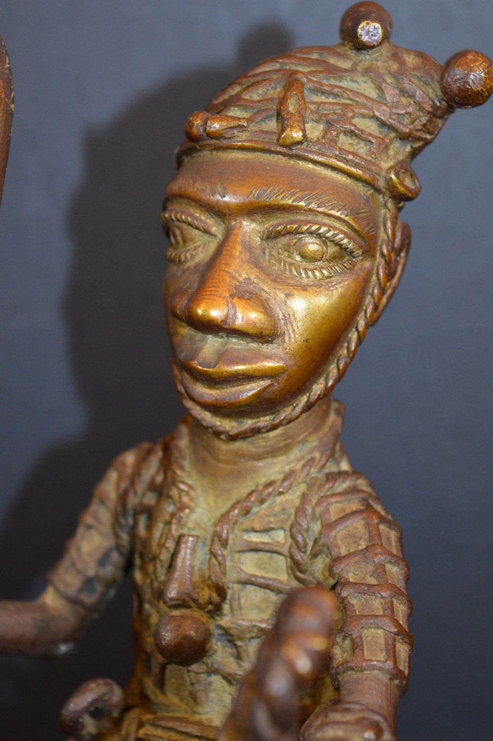 A cast metal Benin style sculpture of a warrior riding a decorated horse on a rectangular base, holding reins and a blade. View VII