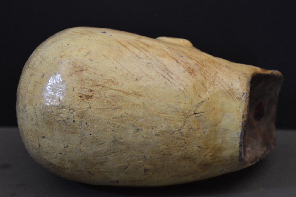 A hand-carved and painted yellow wooden Tibetan Citipati skull featuring deep red eye sockets and sculpted teeth. View IV