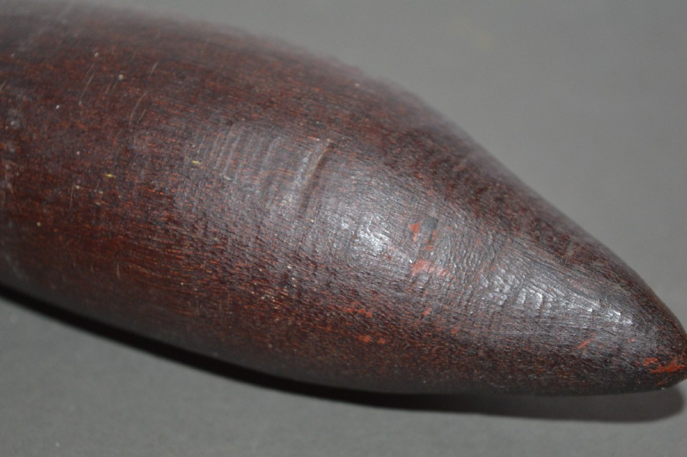 A hand-carved dark hardwood Aboriginal throwing club tapering at both ends with a smooth patinated surface. View V