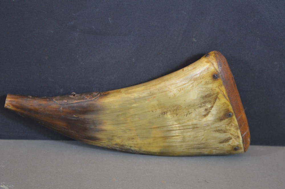 An 18th-century natural curved horn powder flask featuring a fitted wooden base plug pinned with iron tacks and a tapered spout. View II