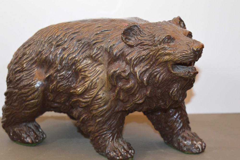 A heavy cast bronze sculpture depicting a bear with textured fur and an open mouth in a walking pose. View II