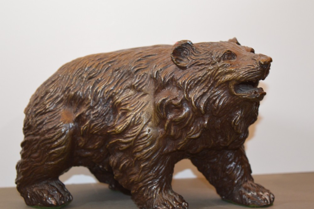 A heavy cast bronze sculpture depicting a bear with textured fur and an open mouth in a walking pose. View III