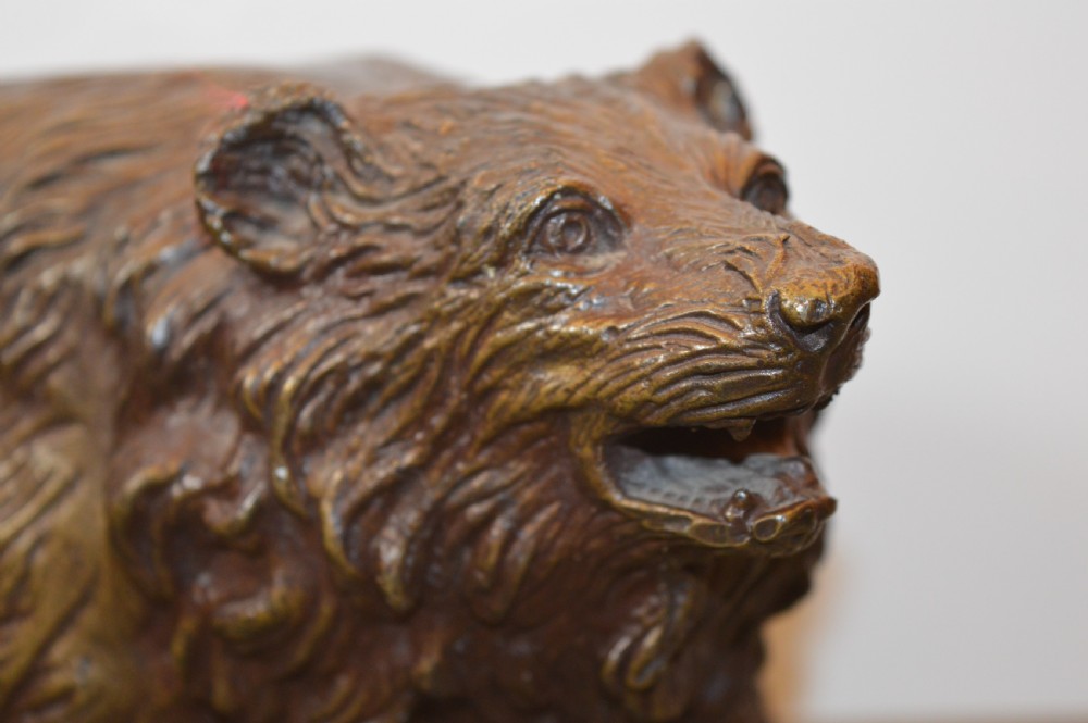 A heavy cast bronze sculpture depicting a bear with textured fur and an open mouth in a walking pose. View IV