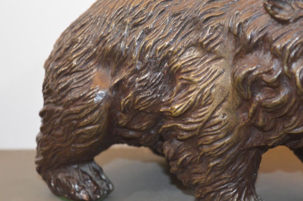 A heavy cast bronze sculpture depicting a bear with textured fur and an open mouth in a walking pose. View VI