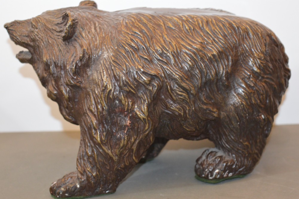 A heavy cast bronze sculpture depicting a bear with textured fur and an open mouth in a walking pose. View VII
