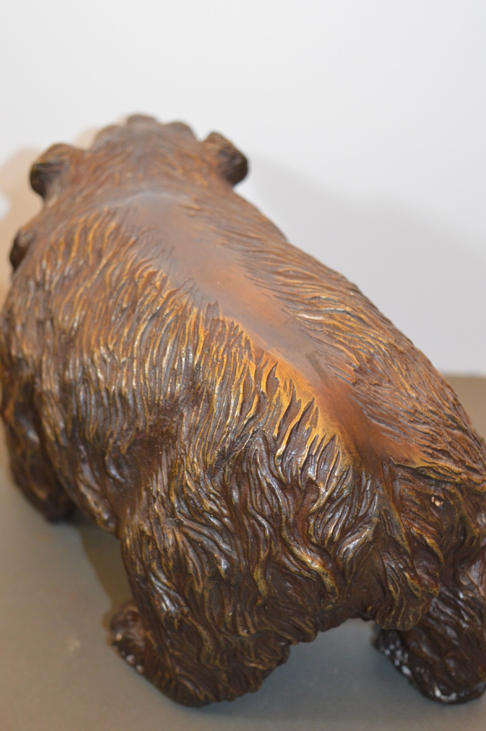 A heavy cast bronze sculpture depicting a bear with textured fur and an open mouth in a walking pose. View IX