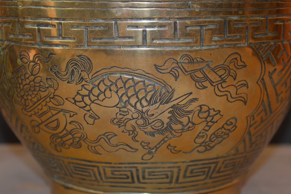 A heavy polished brass Japanese jardiniere with incised dragon artwork and geometric key fret borders around the exterior. View II