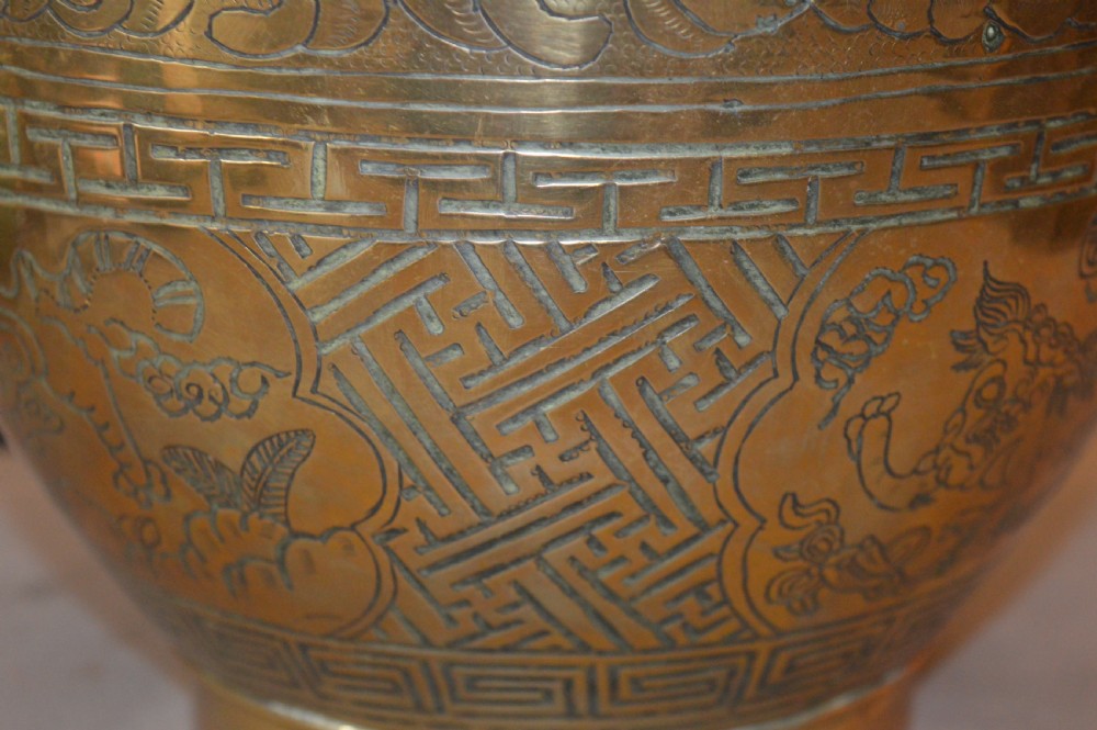 A heavy polished brass Japanese jardiniere with incised dragon artwork and geometric key fret borders around the exterior. View VII