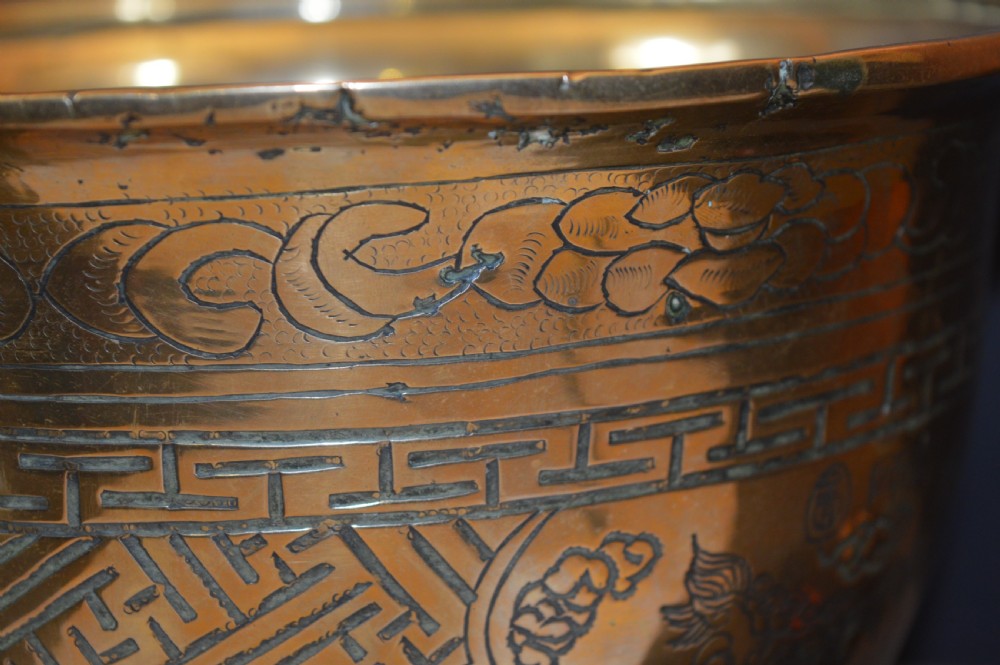 A heavy polished brass Japanese jardiniere with incised dragon artwork and geometric key fret borders around the exterior. View IX