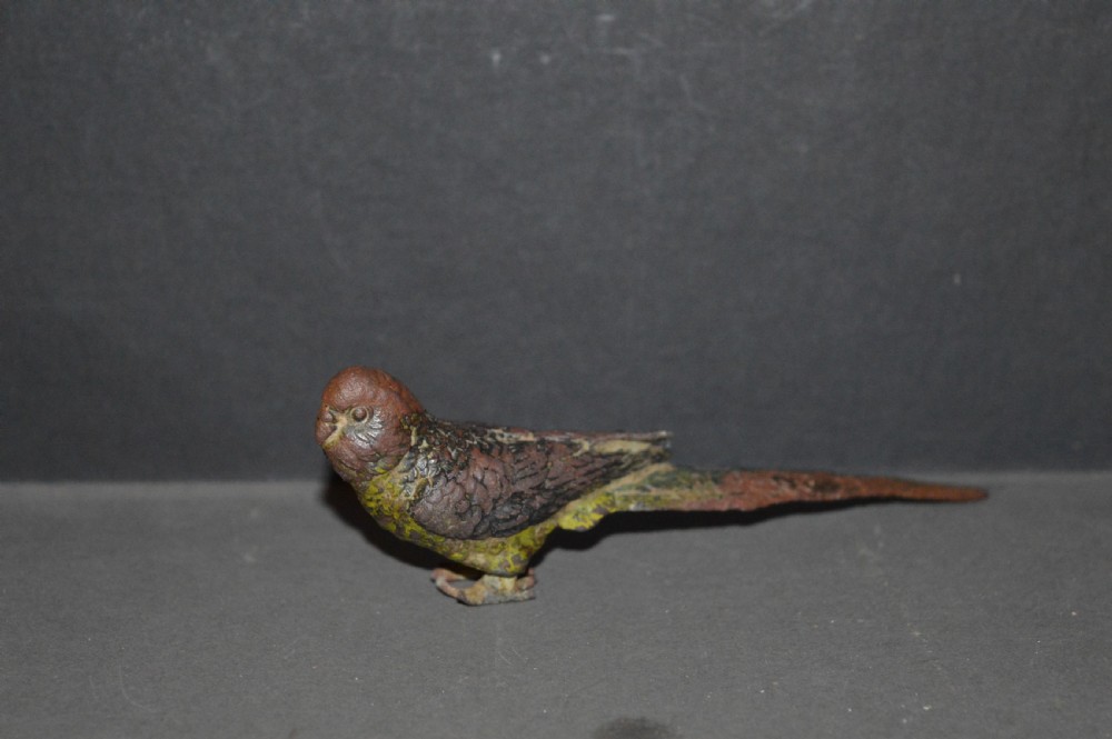A cold-painted bronze figurine depicting a parrot with textured feather details in shades of brown, green, and yellow. View III