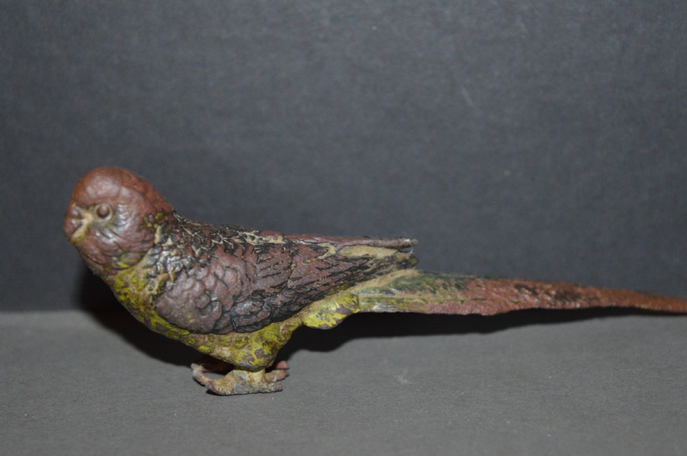 A cold-painted bronze figurine depicting a parrot with textured feather details in shades of brown, green, and yellow. View IV