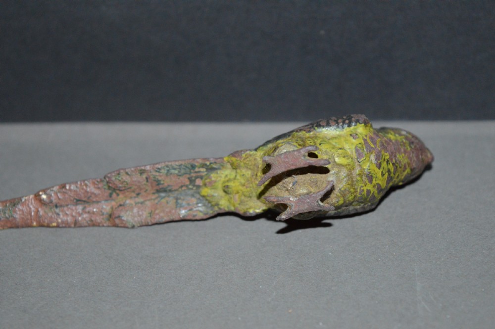 A cold-painted bronze figurine depicting a parrot with textured feather details in shades of brown, green, and yellow. View VI
