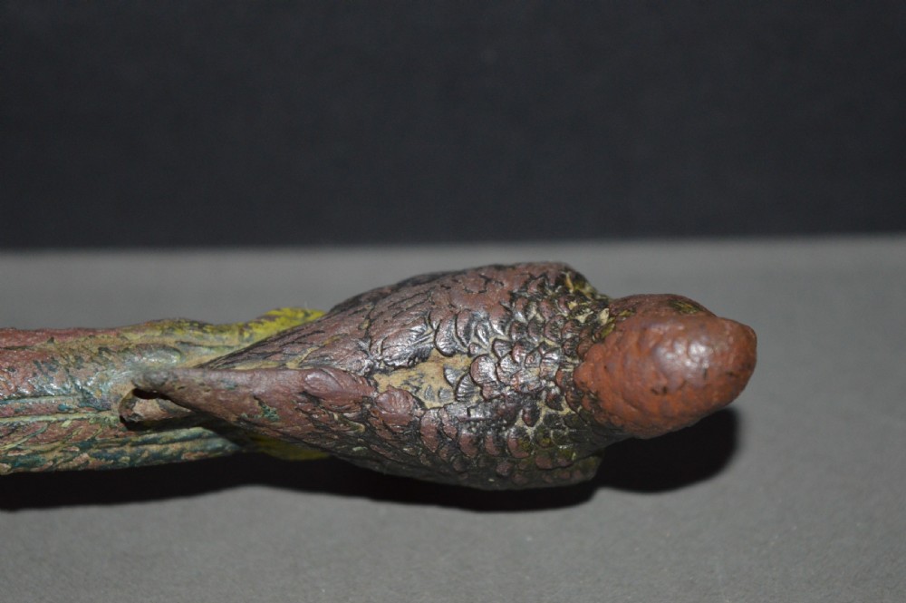 A cold-painted bronze figurine depicting a parrot with textured feather details in shades of brown, green, and yellow. View VII