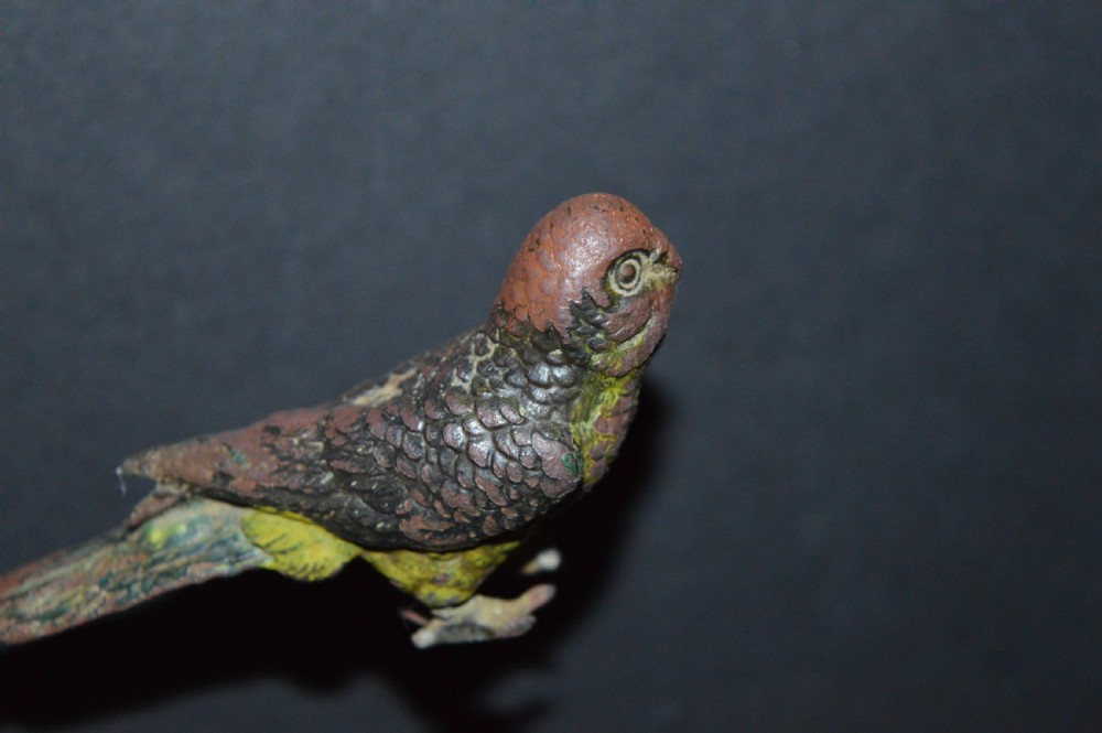 A cold-painted bronze figurine depicting a parrot with textured feather details in shades of brown, green, and yellow. View IX