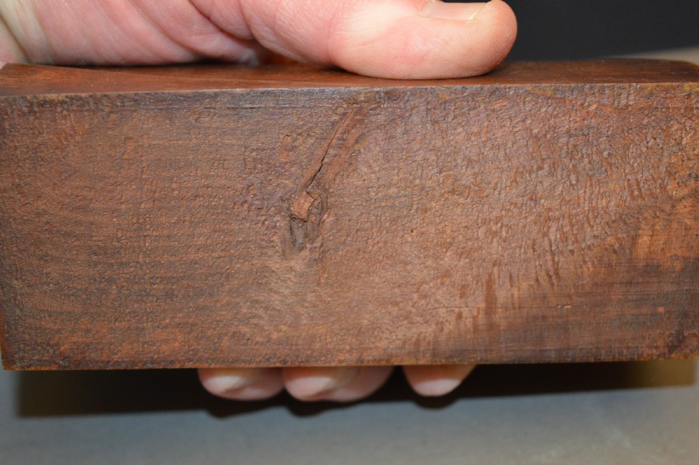 A rectangular wooden block stand fitted with a set of brass apothecary knobbed weights arranged by size. View VIII