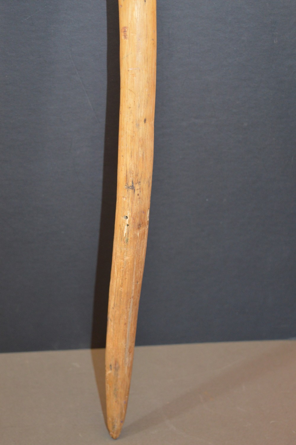 An antique Papua New Guinea fighting club featuring a angled wooden shaft, intricate woven rattan lashing, and a projecting serrated spike. View VII