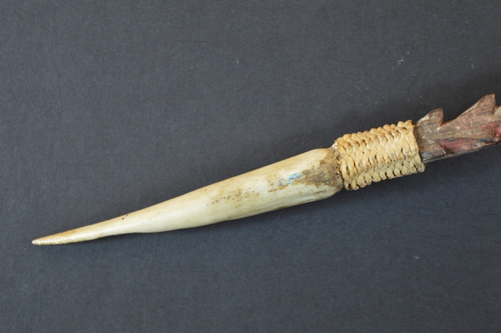 An antique Papua New Guinea fighting club featuring a angled wooden shaft, intricate woven rattan lashing, and a projecting serrated spike. View VIII