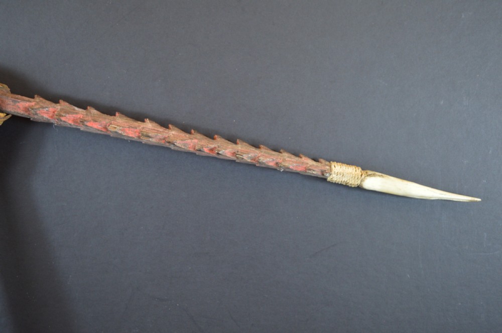 An antique Papua New Guinea fighting club featuring a angled wooden shaft, intricate woven rattan lashing, and a projecting serrated spike. View XII