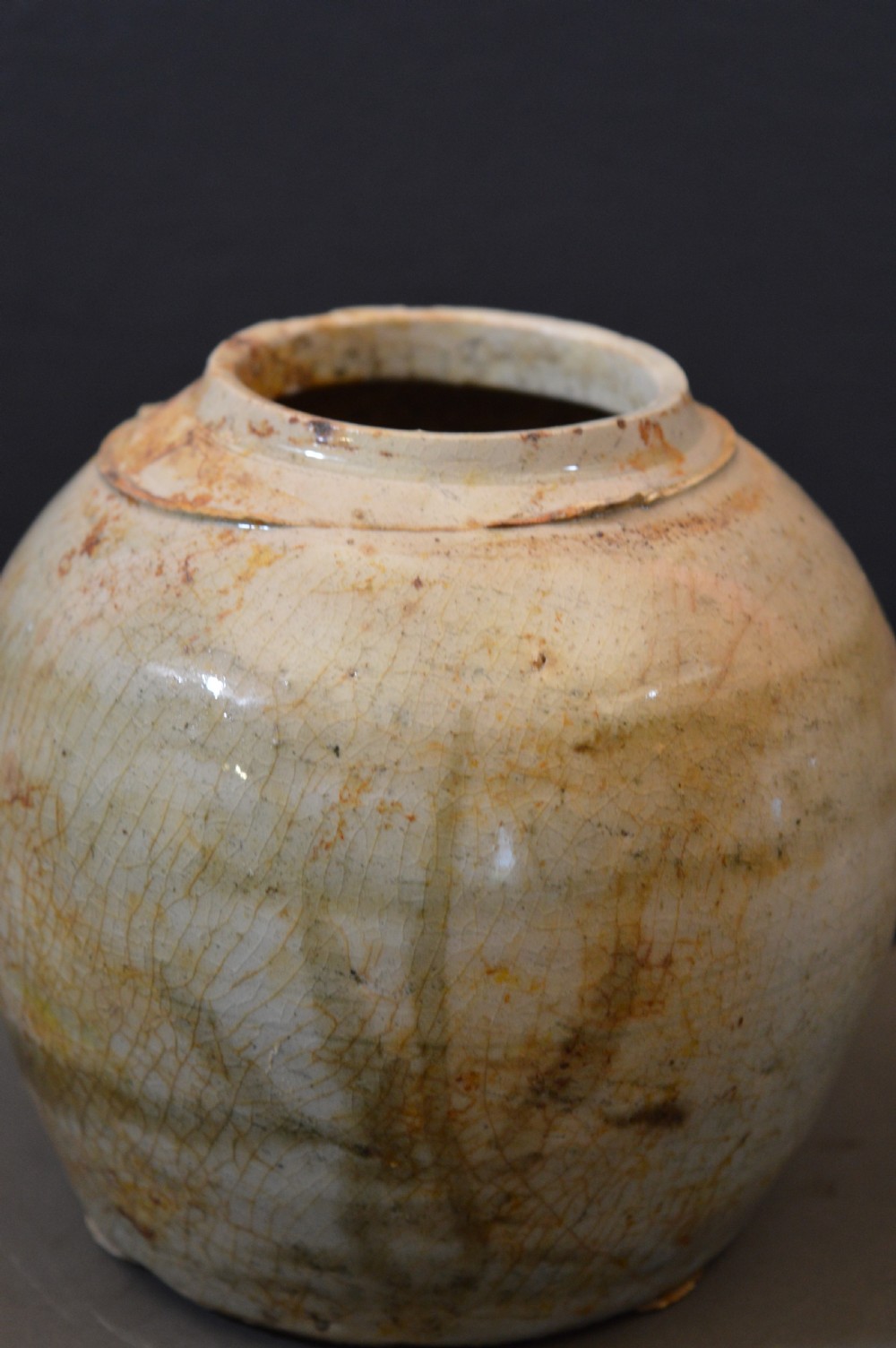 A pair of antique Chinese Ming dynasty ceramic pots featuring short rolled rims, globose bodies, and heavily crackled, patinated cream glazes. View III