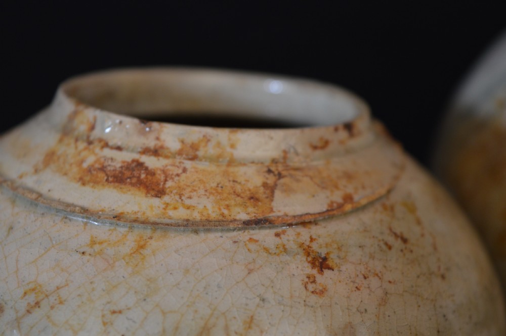 A pair of antique Chinese Ming dynasty ceramic pots featuring short rolled rims, globose bodies, and heavily crackled, patinated cream glazes. View VIII