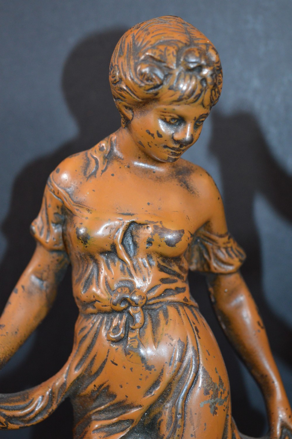 A pair of late nineteenth-century French bronzed metal allegorical female statues titled Modestie and Gaiete, mounted on circular turned wooden bases with brass nameplates. View V