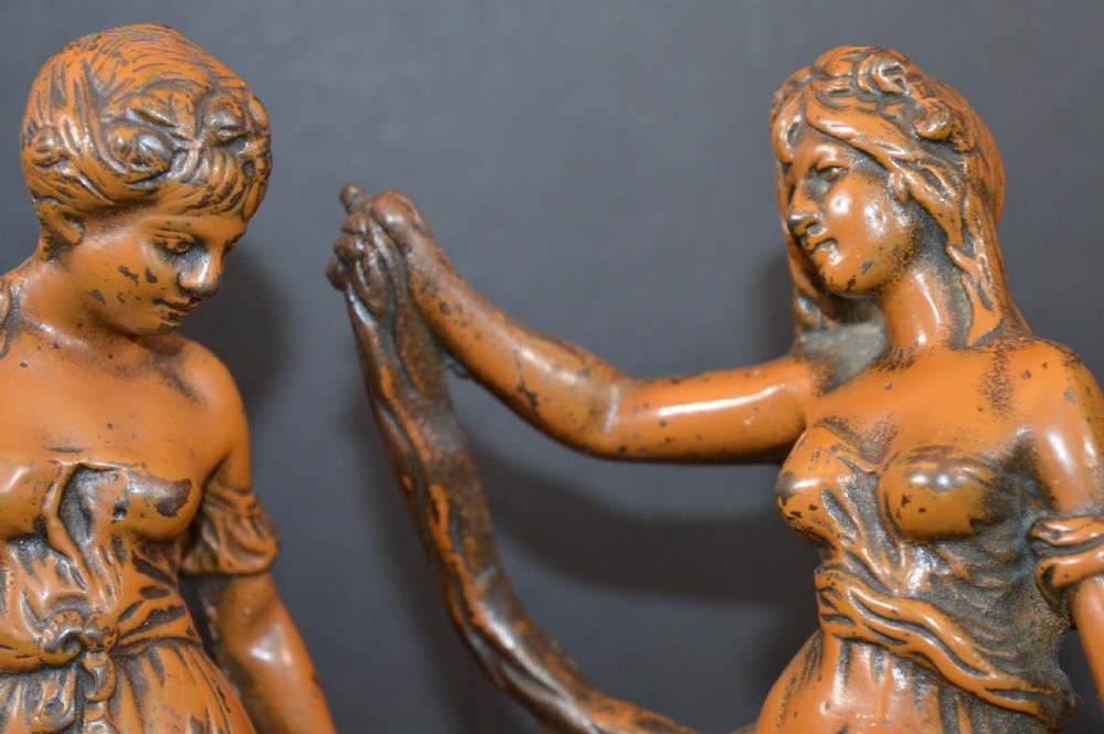 A pair of late nineteenth-century French bronzed metal allegorical female statues titled Modestie and Gaiete, mounted on circular turned wooden bases with brass nameplates. View IX