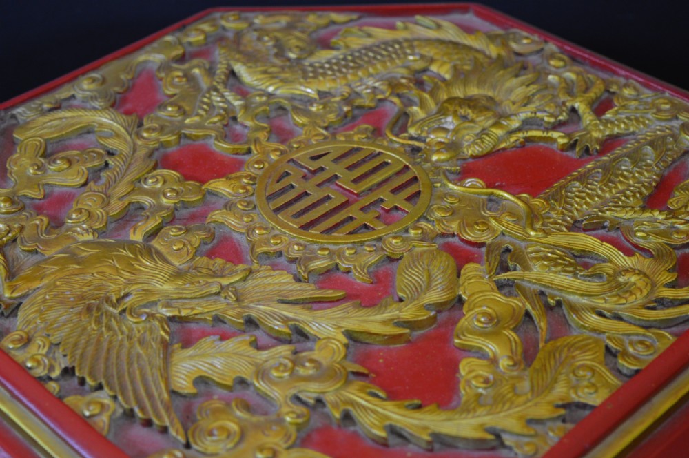 An octagonal Chinese red lacquer wedding box with relief-carved gold dragon and lotus motifs. View VI