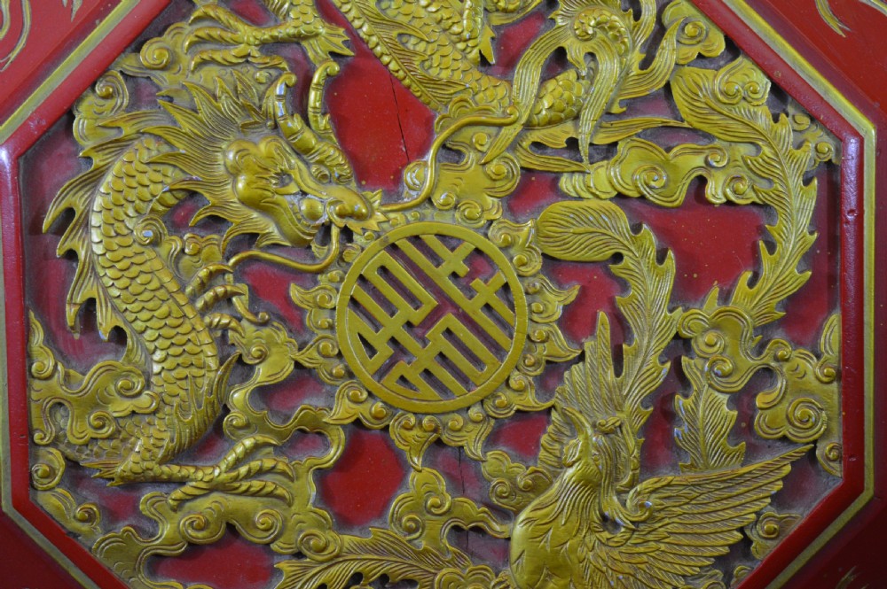 An octagonal Chinese red lacquer wedding box with relief-carved gold dragon and lotus motifs. View IX