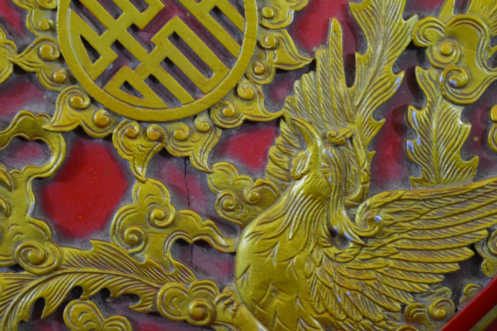 An octagonal Chinese red lacquer wedding box with relief-carved gold dragon and lotus motifs. View XI