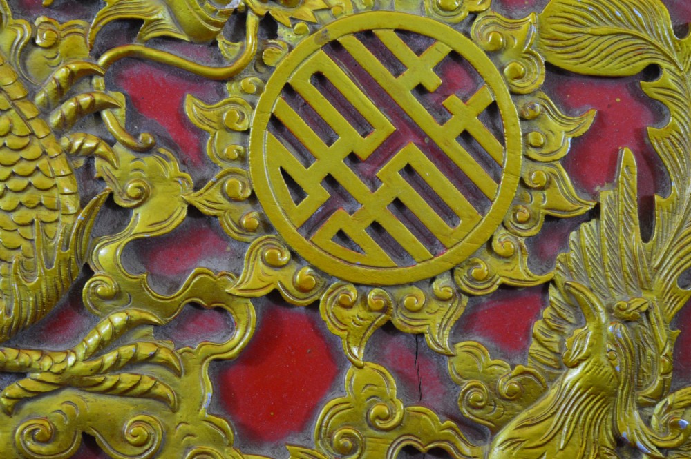 An octagonal Chinese red lacquer wedding box with relief-carved gold dragon and lotus motifs. View XII