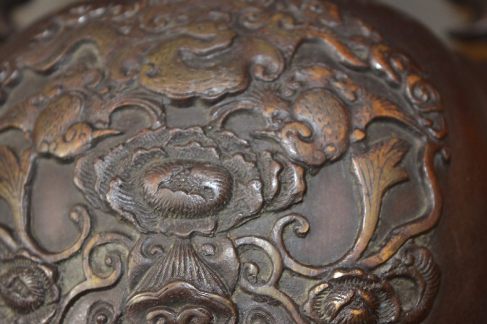 A heavy dark brown bronze Chinese incense burner featuring sculpted dragon handles, relief-carved medallions, and tall cabriole legs mounted on a round stand. View XI