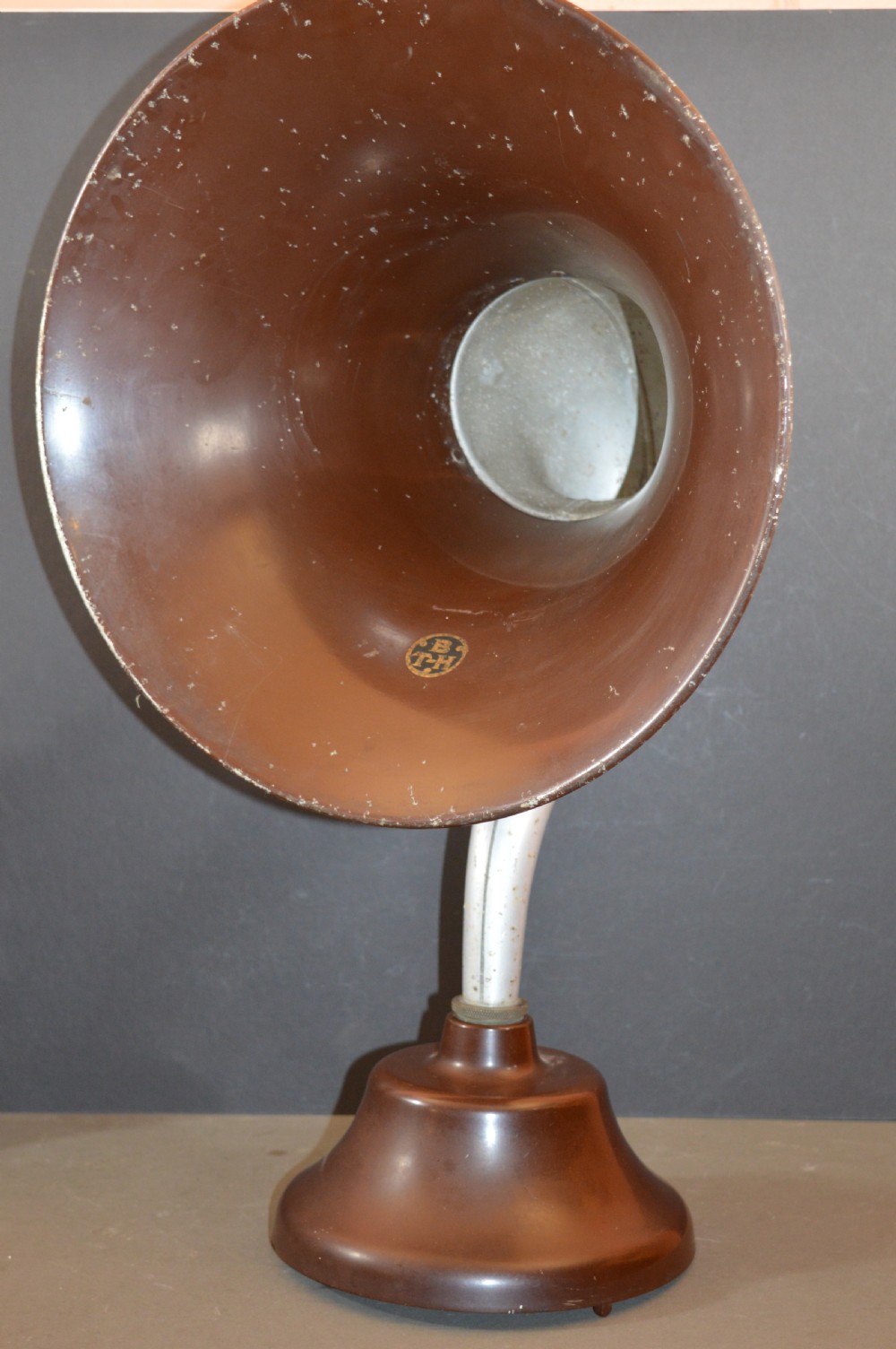 An antique 1930s British Thomson-Houston horn loudspeaker with a flared dark brown Bakelite bell, a curved silver metal neck, and a matching rounded Bakelite base. View II