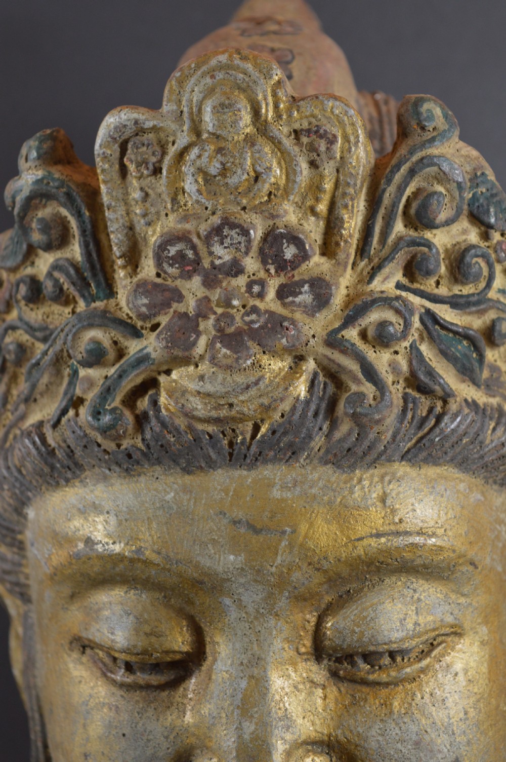 A late 19th-century cast iron head sculpture of Guanyin featuring detailed scrollwork tiara and residual gold gilding. View X