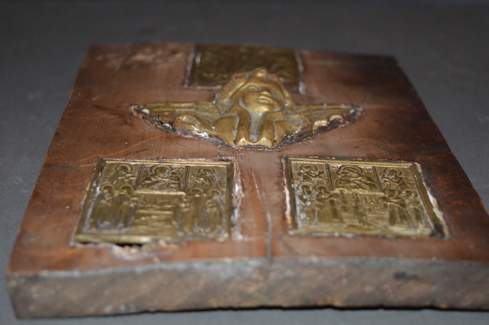 A rectangular wooden panel featuring three square brass Russian icons and a central relief of a winged angel head. View VIII
