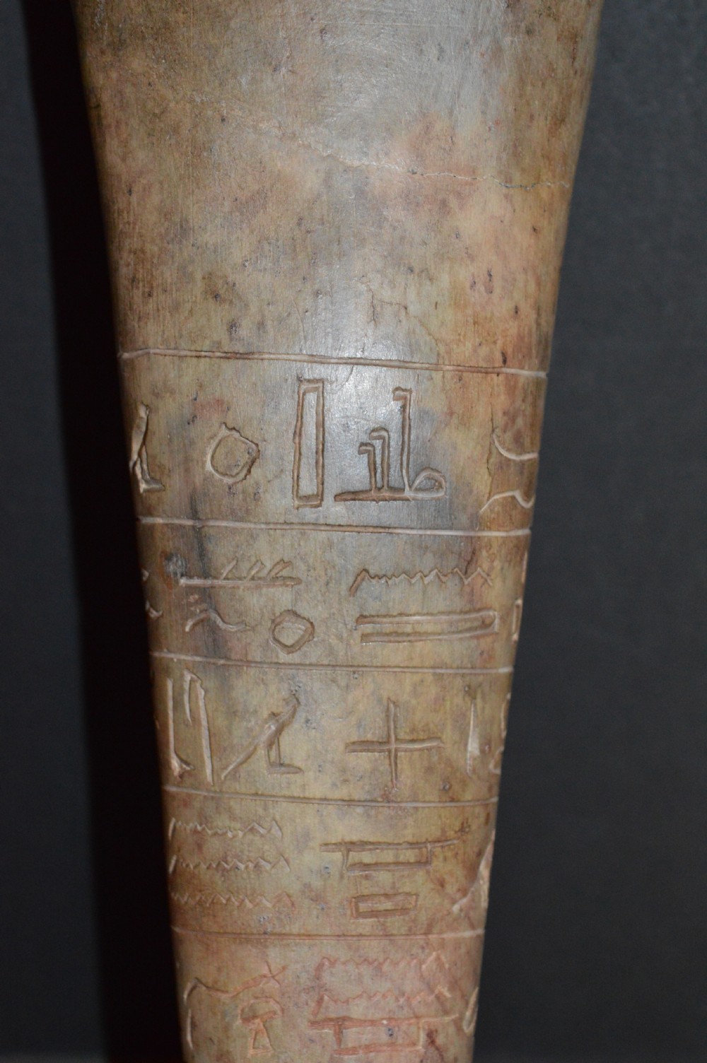 A carved beige stone model of an Egyptian sarcophagus lid featuring a pharaonic face with a nemes headdress and hieroglyphic engravings. View IX
