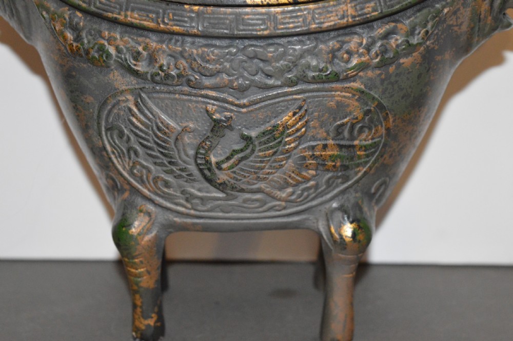 A late Qing dynasty dark parcel-gilt bronze censer featuring raised phoenix relief panels, extended vertical handles, and a serpent finial lid. View II