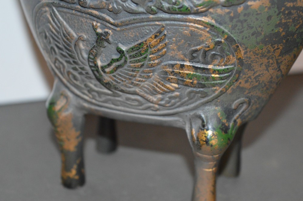 A late Qing dynasty dark parcel-gilt bronze censer featuring raised phoenix relief panels, extended vertical handles, and a serpent finial lid. View IX
