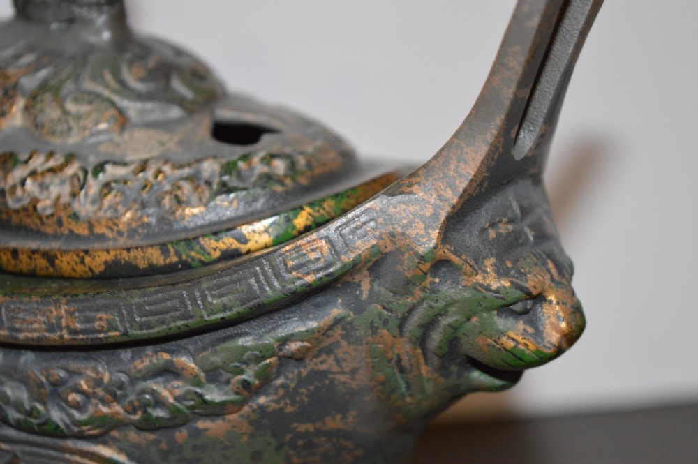 A late Qing dynasty dark parcel-gilt bronze censer featuring raised phoenix relief panels, extended vertical handles, and a serpent finial lid. View X